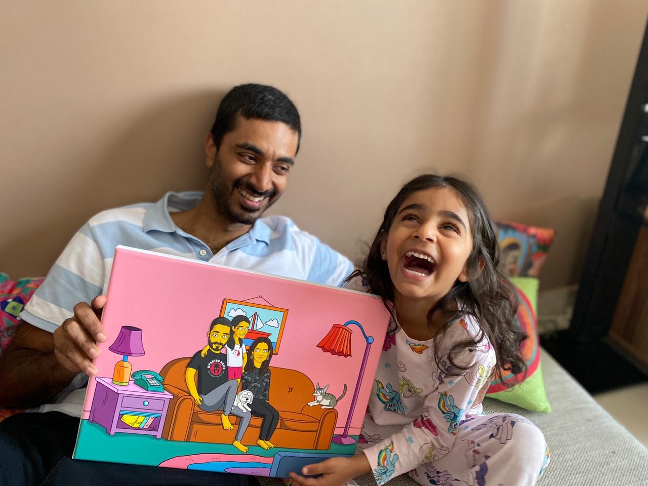 Father and daughter laughing holding a canvas of themselves