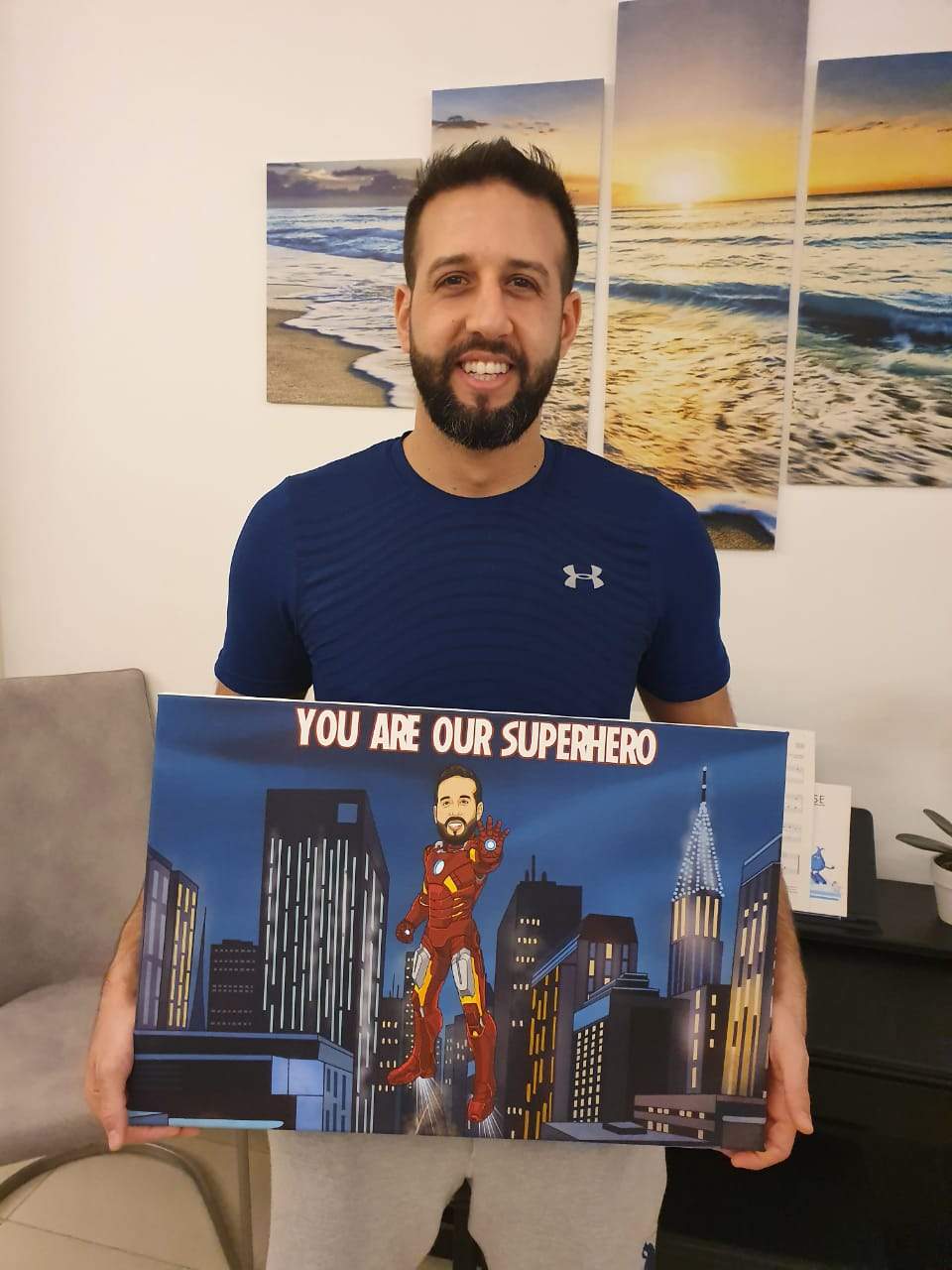 man holding a super hero canvas he received as a gift