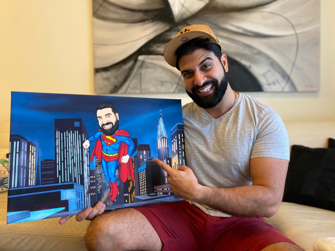 Man holding and pointing to a super man canvas, blue, yellow and red costume 